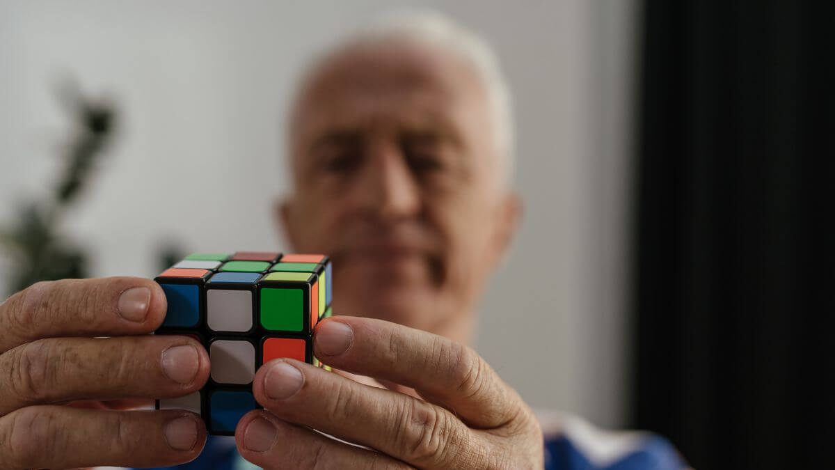 an old man solving rubik's cube